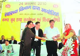 Deputy commissioner Ajit Joshi (second from right) gives away cash reward of Rs 50,000 to Sunita (right), mahila sarpanch of Butana Kundu village