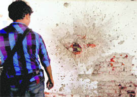 A man looks at a wall damaged during the 26/11 terror attack at the Nariman House, in Mumbai on Thursday.