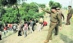 Policemen disperse agitating daily wage workers of the PDD in Jammu
