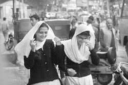 Students cover their heads during rain in Jammu