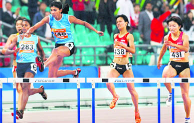 Ashwini Chidananda Akkunji (248) clears a hurdle on her way to win the women's 400m hurdles event in Guangzhou on Thursday.  Reuters
