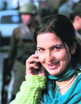 A Kashmiri girl all smiles while talking on her mobile phone at Lal Chowk in Srinagar where normal life has resumed after a long period of unrest. 