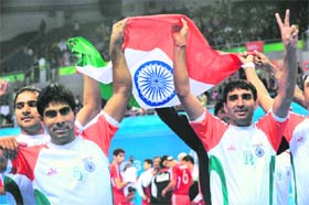 The Indian team carry their national flag on a victory lap after beating Iran in the kabaddi men's final match in Guangzhou on Friday. India beat Iran 28-16 for the gold medal. 
