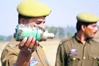 A policeman shows a rocket launcher shell recovered from Kotli Charkan village in Bishnah tehsil of Jammu