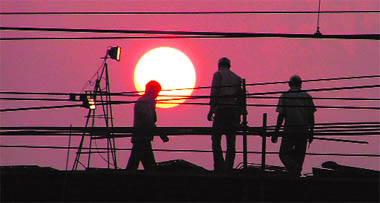 Workers engaged in the railway overbridge project call it a day as the sun sets in Ludhiana on Saturday.