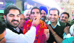 Manjeet Singh, an Asian Games medallist, is given a ladoo by a resident when he was received at Ferozepur railway station on Saturday. Deputy Commissioner KK Yadav is also seen in the picture.