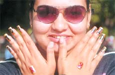 A volunteer spreads awareness about HIV AIDS by painting a message on her nails under the junoon campaign at the Chandigarh Carnival on Sunday. 