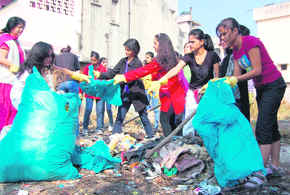 Participants in a beauty contest lift garbage from a vacant plot in the Kishan Nagar Chowk area of Dehradun on Sunday.