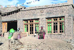 A resident on Sunday sits in front of his house damaged in the cloudburst in Leh. Funds promised by the Centre to help local people reclaim agricultural land are yet to reach the local authorities.