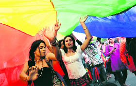 A rainbow flag is carried by gay rights supporters during the Queer Pride Parade in New Delhi on Sunday.