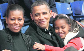 President Barack Obama enjoys a basketball game with wife Michelle and daughter Sasha in Washington.