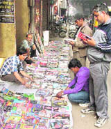 Buyers go through second-hand books that are sold in the Sunday market, near the Clock Tower, in Ludhiana.
