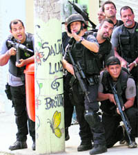 TAKING ON drug traffickers : Armed police gather as they take part in a raid on the shanty town of Alemao in Rio de Janeiro on Sunday. After days of preparation, Brazilian security forces launched a raid against a slum where between 500 and 600 drug traffickers are holed up and refuse to surrender.