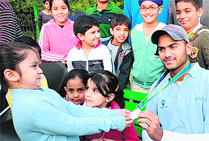Budding golfers of the CGA admire the medal of Asiad silver medallist Abhijit Chadha in Chandigarh on Monday.