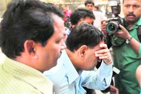 CBI investigators escort one of the eight suspects arrested in connection with loans-for-bribes scandal to the Sessions Court in Mumbai on Monday. The eight, including a top official of the LIC Housing Finance and senior executives of state-run banks, were detained last week for allegedly giving and receiving bribes for sanctioning loans to a number of firms, including property developers. 