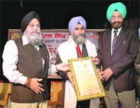 Painter RM Singh (centre) being honoured with Sobha Singh Puraskarby Punjabi University, Patiala, at a function on Monday. 