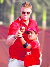 Former England cricketer Andrew Flintoff gives tips to a young player in Mumbai on Monday. 