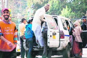 Commuters try to squeeze in an overcrowded HRTC taxi at Shimla.