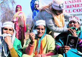 A relative of a disappeared person consoles Zahida, mother of Mohd Shafi Lone(19) of Nadihal in Baramulla district (R), who was killed in an alleged fake encounter at Macchil Kupwara in April, 2010,