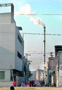 Thick smoke billows out of a chimney of an industrial unit in Ludhiana