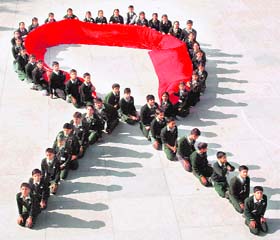 Schoolchildren form the AIDS logo on the eve of World AIDS Day, in Amritsar