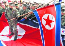 Retired South Korean soldiers hold defaced North Korean flags before burning them during an anti-North Korea rally in Seoul on Tuesday.