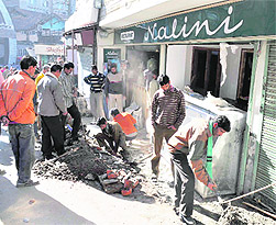 MC workers remove encroachment by restaurant Nalini on the Mall in Shimla on Wednesday. 