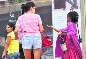 A beggar pesters a foreigner for alms in Gurgaon