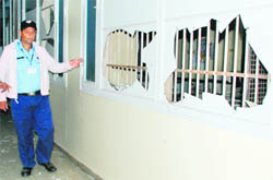 A security guard shows damaged windowpanes of the MS office at the PGI on Friday