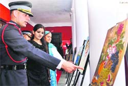 A cadet of the Army Cadet College shows a painting at an exhibition put up by cadets in Dehradun on Friday.