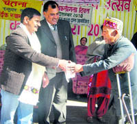 Additional District Magistrate RK Pruthi gives a prize to a differently abled at a function in Kullu on Friday. 