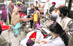 An attendant holds an IV drip at the Civil Hospital in Ludhiana