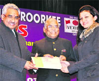 Uttarakhand Urban Development Minister Madan Kaushik honours a student during a function at the College of Engineering Roorkee on Friday.