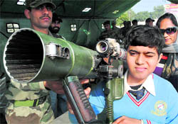 A schoolboy handles weapons during an Army exhibition and fair at the Army Cantonment in Patiala on Saturday