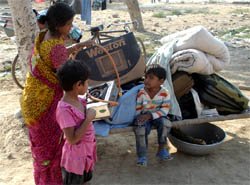 A woman along with her kids awaiting shelter outside the Labour Colony that was demolished on Saturday