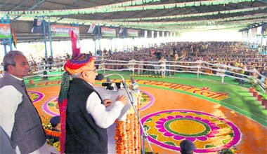 Chief Minister Bhupinder Singh Hooda addresses a rally at Fatehabad on Sunday. Also in the picture is Chief Parliamentary Secretary Prahlad Singh Gillankhera