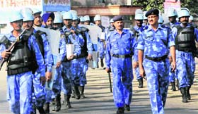 Police and Rapid Action Force personnel patrol a street as part of enhanced security measures on the 18th anniversary of Babri Masjid demolition, in Lucknow on Sunday. 