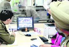 The police examines CCTV footage at HDFC Bank, Sector 17, Chandigarh, on Monday.