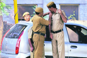 A security guard affixes a badge on his colleagues uniform in Faridabad. 