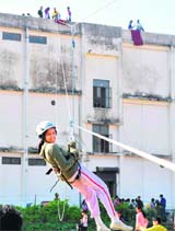 A student slides down via ropes from atop a building at an adventure camp in Haridwar on Tuesday.