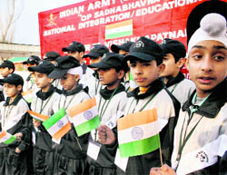 Children hold the Tricolour before leaving on an educational tour organised by the Army to celebrate 