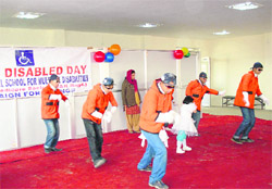 Children of Shafaqat Special School give a performance on the occasion of the World Disability Day in Srinagar.