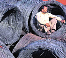 A labourer sits on an iron coil at a railway yard in Chandigarh on Wednesday