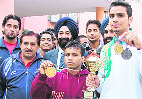 Arpinder Singh (white track suit) and Vicky Kumar (red track suit) with their medals in Ludhiana on Wednesday. 