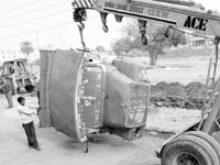 Parts of dumped vehicles being removed from a parking lot at the Mani Majra motor market on Friday.