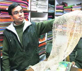 A salesperson at the Panchachuli shop shows a scarf woven from giant nettle plants in Mussoorie.