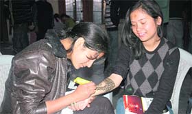 Two girls participate in a mehndi competition at the Union Week celebrations of DAV PG College in Dehradun on Friday.