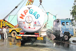 Fire brigade personnel try to control a leakage in an HP Gas tanker, which met with an accident with a goods container near Karontha village on the Rohtak-Jaipur highway