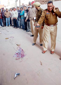 Cops examine the spot where a boy shot a girl dead and committed suicide later, on the Mall road in Bathinda on Saturday.
