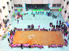 Students of Ryan International School work on creating the largest handmade recycled paper in Ludhiana on Saturday.